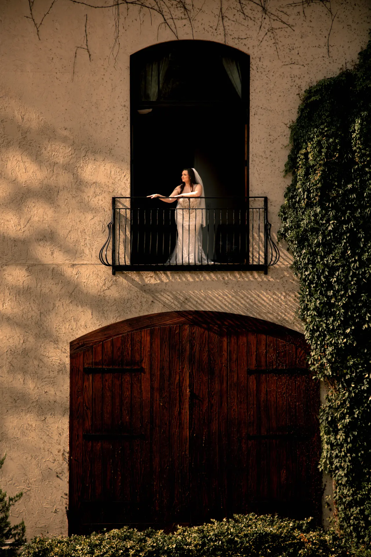 Bride standing on a balcony in warm afternoon light